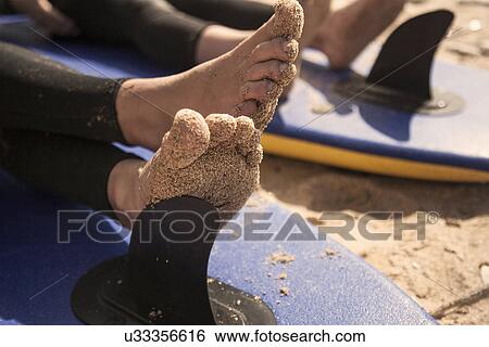 Stock Photograph - Boy's feet on surfboard, close up. Fotosearch