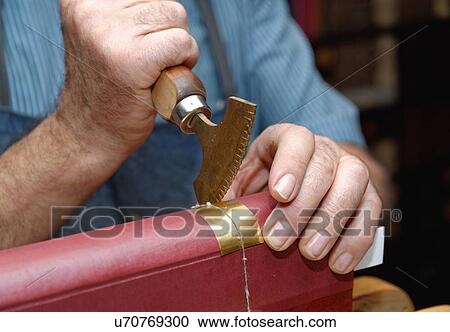 Close up of hands of senior male traditional bookbinder pressing gold leaf onto book spine View Large Photo Image Stock Image - Close up of hands of senior male traditional bookbinder pressing gold leaf onto book spine. Fotosearch