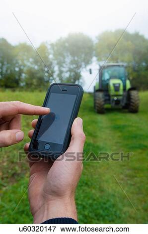 Close up of male farmers hand using touchscreen on smartphone in field View Large Photo Image Stock Photo - Close up of male farmers hand using touchscreen on smartphone in field. Fotosearch