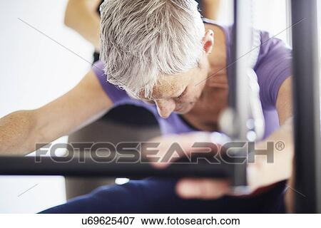 Stock Photo - Close up of woman practicing pilates on trapeze table in pilates gym. Fotosearch