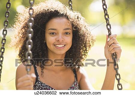Close up portrait of young woman sitting on park swing View Large Photo Image Stock Image - Close up portrait of young woman sitting on park swing. Fotosearch