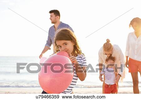 Stock Photo - Couple and mid adult woman with two girls on beach, Tuscany, Italy. Fotosearch