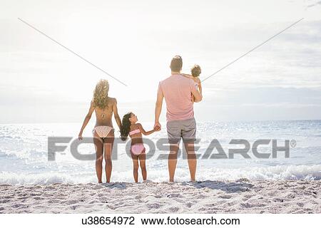 Stock Image - Couple and two girls gazing out to sea, Tuscany, Italy. Fotosearch