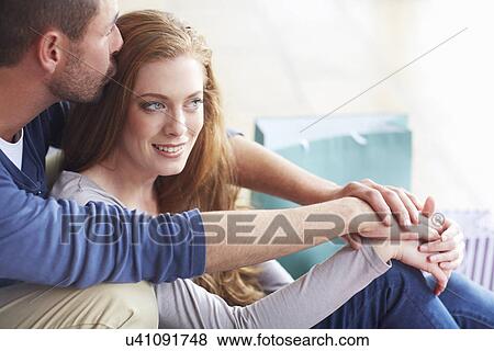 Stock Photo - Couple embracing, man kissing woman's head. Fotosearch