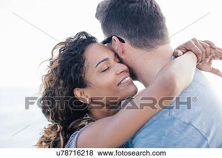 Stock Photo - Couple hugging on beach, Tuscany, Italy. Fotosearch