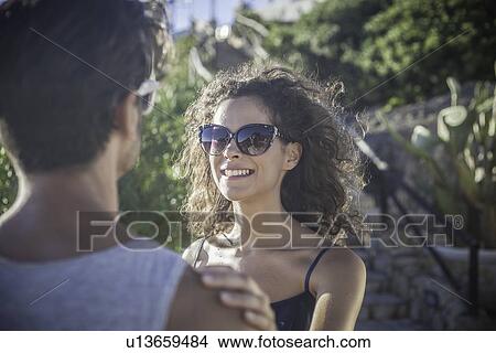Picture - Couple in sunlight, woman wearing sunglasses. Fotosearch