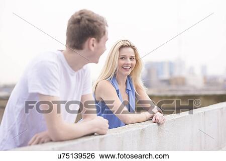 Couple leaning on wall View Large Photo Image Stock Photograph - Couple leaning on wall. Fotosearch