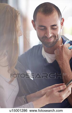Couple looking at digital tablet View Large Photo Image Stock Photograph - Couple looking at digital tablet. Fotosearch
