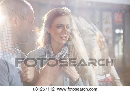 Stock Image - Couple shopping, looking in shop window. Fotosearch