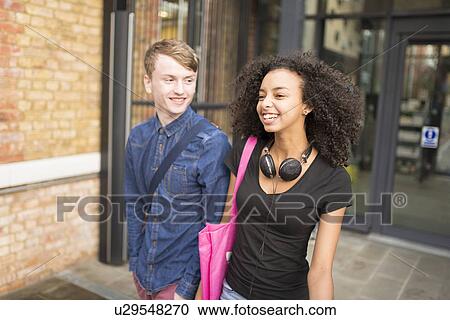 Stock Image - Couple smiling, woman with headphones. Fotosearch