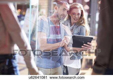 couple window shopping, holding digital tablet View Large Photo Image Stock Image - couple window shopping, holding digital tablet. Fotosearch