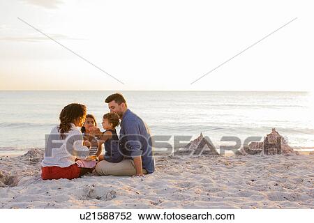 Couple with two girls eating cakes on beach, Tuscany, Italy View Large Photo Image Stock Image - Couple with two girls eating cakes on beach, Tuscany, Italy. Fotosearch