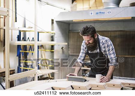 Cropped shot of mid adult craftsman using digital tablet in organ workshop View Large Photo Image Stock Image - Cropped shot of mid adult craftsman using digital tablet in organ workshop. Fotosearch
