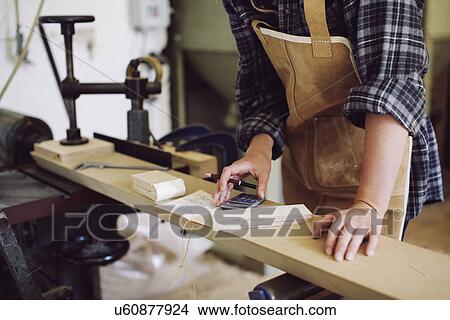 Cropped shot of young craftswoman using calculator in pipe organ workshop View Large Photo Image Picture - Cropped shot of young craftswoman using calculator in pipe organ workshop. Fotosearch
