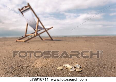 Deck chair on beach, coins on sand in foreground View Large Photo Image Stock Image - Deck chair on beach, coins on sand in foreground. Fotosearch