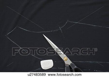 Dressmakers pattern outlined in chalk on black textile in workshop View Large Photo Image Stock Photo - Dressmakers pattern outlined in chalk on black textile in workshop. Fotosearch