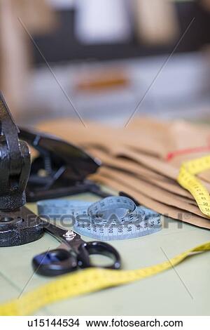 Dressmakers pattern, scissors and tape measure on work table in workshop View Large Photo Image Picture - Dressmakers pattern, scissors and tape measure on work table in workshop. Fotosearch