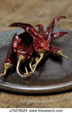Picture - Dried red chillies on a plate, close-up. Fotosearch
