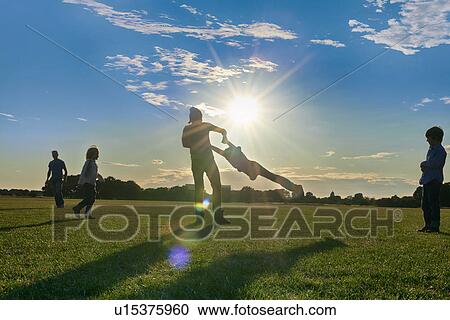 Stock Image - Family enjoying outdoor activities in the park. Fotosearch