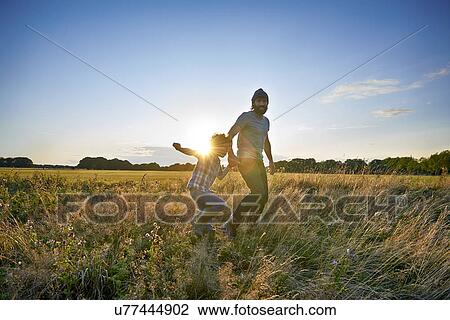 Father and son out walking in the park View Large Photo Image Stock Image - Father and son out walking in the park. Fotosearch