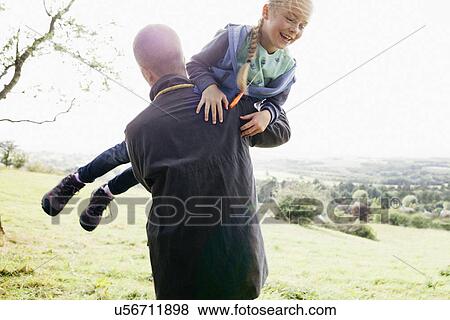 Stock Photo - Father carrying daughter in arms. Fotosearch