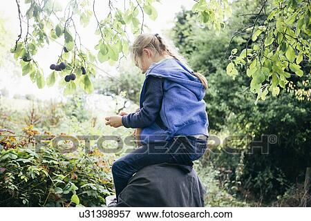 Stock Photo - Father carrying daughter on shoulders. Fotosearch