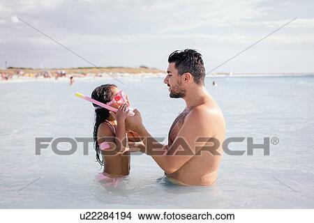 Father teaching daughter how to snorkel in sea, Tuscany, Italy View Large Photo Image Picture - Father teaching daughter how to snorkel in sea, Tuscany, Italy. Fotosearch
