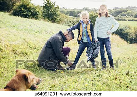 Father tying daughter's shoelace in field View Large Photo Image Stock Image - Father tying daughter's shoelace in field. Fotosearch