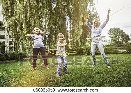 Female members of family playing with hula hoop View Large Photo Image Stock Photo - Female members of family playing with hula hoop. Fotosearch