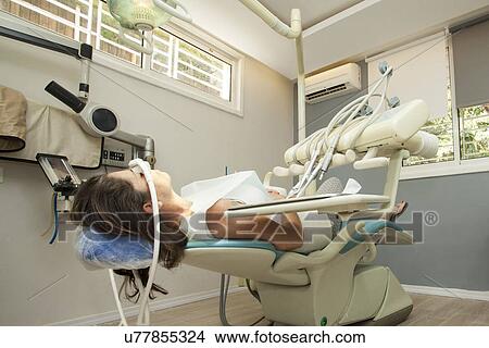 Picture - Female patient awaits the dentist in surgery. Fotosearch