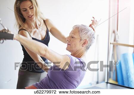 Female student and teacher practicing pilates on trapeze table in pilates gym View Large Photo Image Stock Image - Female student and teacher practicing pilates on trapeze table in pilates gym. Fotosearch