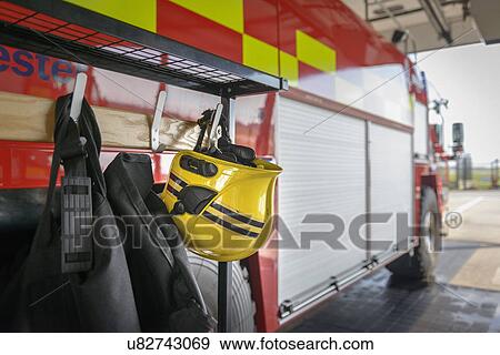 Fireman's helmet hanging by fire engine in fire station View Large Photo Image Stock Photo - Fireman's helmet hanging by fire engine in fire station. Fotosearch