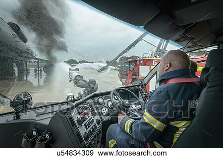 Firemen in cab of fire engine at airport training facility View Large Photo Image Stock Photo - Firemen in cab of fire engine at airport training facility. Fotosearch