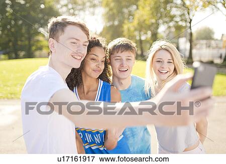 Four young adult basketball players posing for smartphone selfie View Large Photo Image Stock Photo - Four young adult basketball players posing for smartphone selfie. Fotosearch