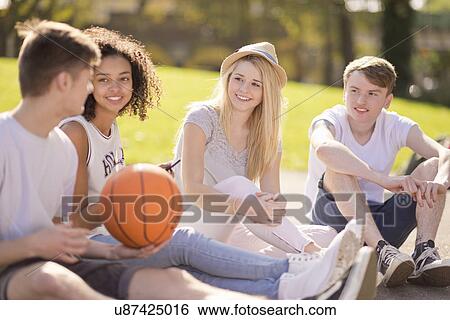Four young adult basketball players sitting chatting View Large Photo Image Stock Photograph - Four young adult basketball players sitting chatting. Fotosearch
