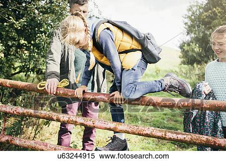 Girl climbing over wooden fence View Large Photo Image Stock Photography - Girl climbing over wooden fence. Fotosearch