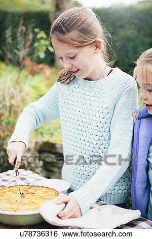 Stock Photograph - Girl cutting homemade pie. Fotosearch