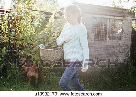 Girl holding basket in garden View Large Photo Image Stock Photo - Girl holding basket in garden. Fotosearch