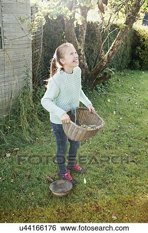 Girl holding basket in garden View Large Photo Image Stock Photograph - Girl holding basket in garden. Fotosearch