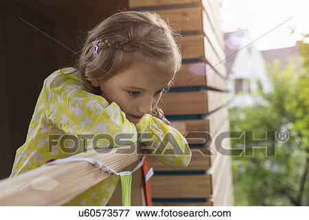 Stock Photo - Girl leaning over tree house. Fotosearch