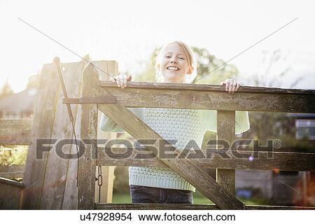Girl looking over wooden gate View Large Photo Image Picture - Girl looking over wooden gate. Fotosearch
