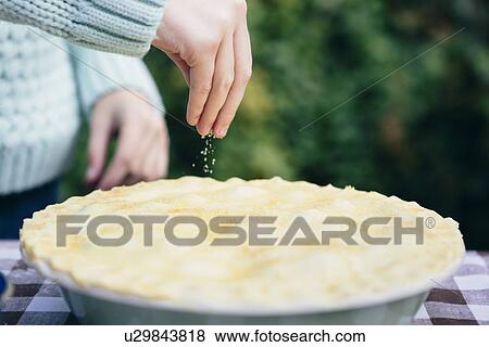 Girl sprinkling sugar on homemade pie View Large Photo Image Stock Photo - Girl sprinkling sugar on homemade pie. Fotosearch