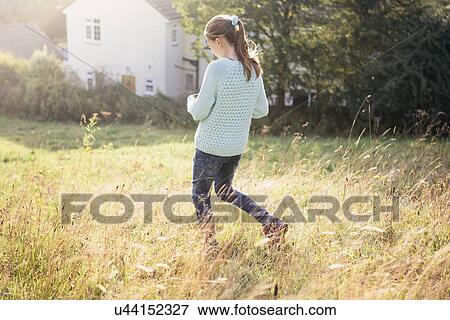 Stock Photo - Girl walking through field. Fotosearch