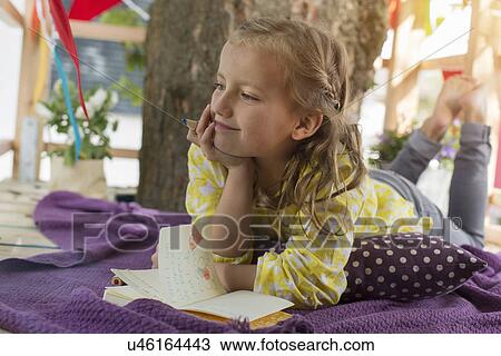 Girl with colouring book in tree house View Large Photo Image Stock Image - Girl with colouring book in tree house. Fotosearch