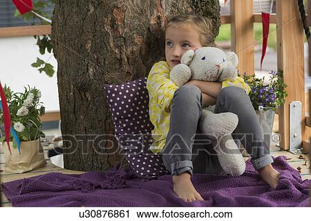 Girl with soft toy in tree house View Large Photo Image Stock Image - Girl with soft toy in tree house. Fotosearch