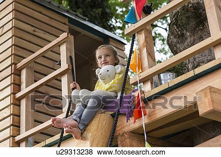 Girl with soft toy in tree house View Large Photo Image Stock Photo - Girl with soft toy in tree house. Fotosearch