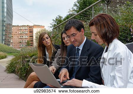 Group of adults looking laptop screen View Large Photo Image Picture - Group of adults looking laptop screen. Fotosearch