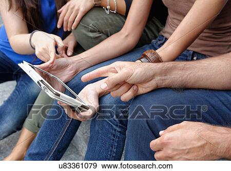 Group of friends looking at digital tablet, focus on tablet and hands View Large Photo Image Stock Photo - Group of friends looking at digital tablet, focus on tablet and hands. Fotosearch