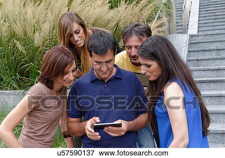 Group of friends looking at smartphone View Large Photo Image Stock Photo - Group of friends looking at smartphone. Fotosearch