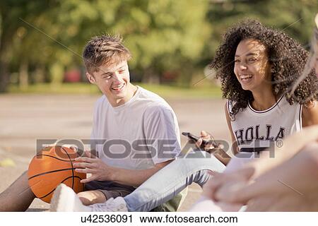 Group of young adult basketball players sitting chatting View Large Photo Image Stock Image - Group of young adult basketball players sitting chatting. Fotosearch